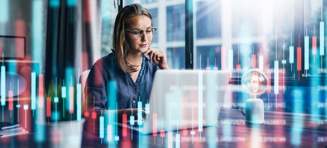 woman sitting at an office desk surrounded by abstract graphs signifying the importance of data in revenue intelligence