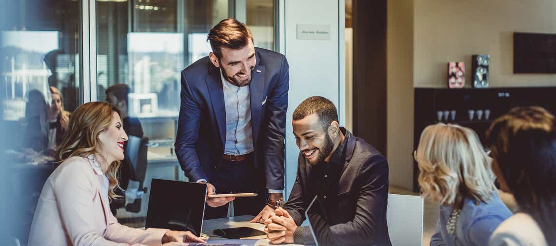 a team of account managers around a conference room table working together to apply the strategies discussed in the prosperous account strategy program to find new revenue opportunities in their top accounts.