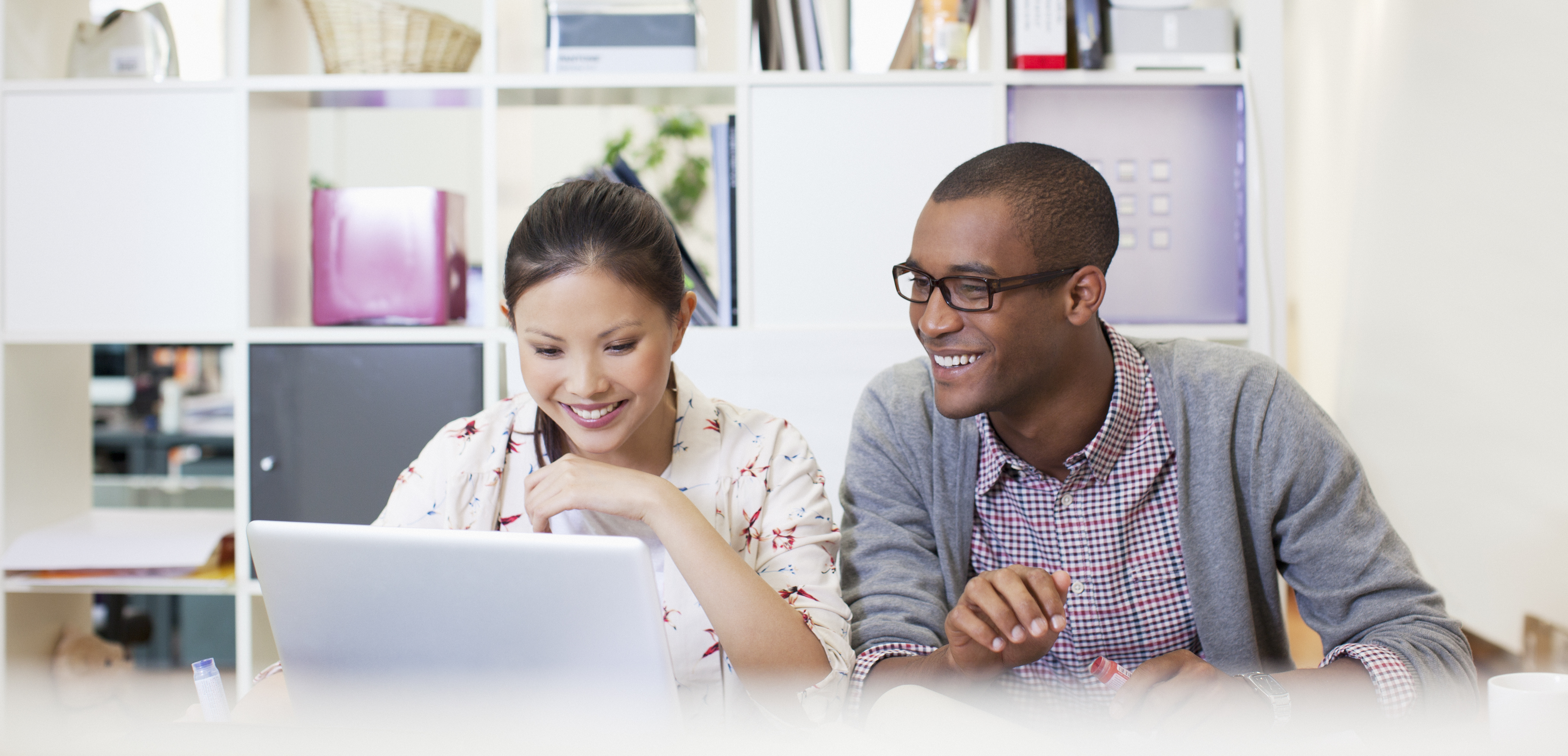 young revenue operations and sales operations professionals sitting together at a modern desk working together to optimize their organization's sales efforts