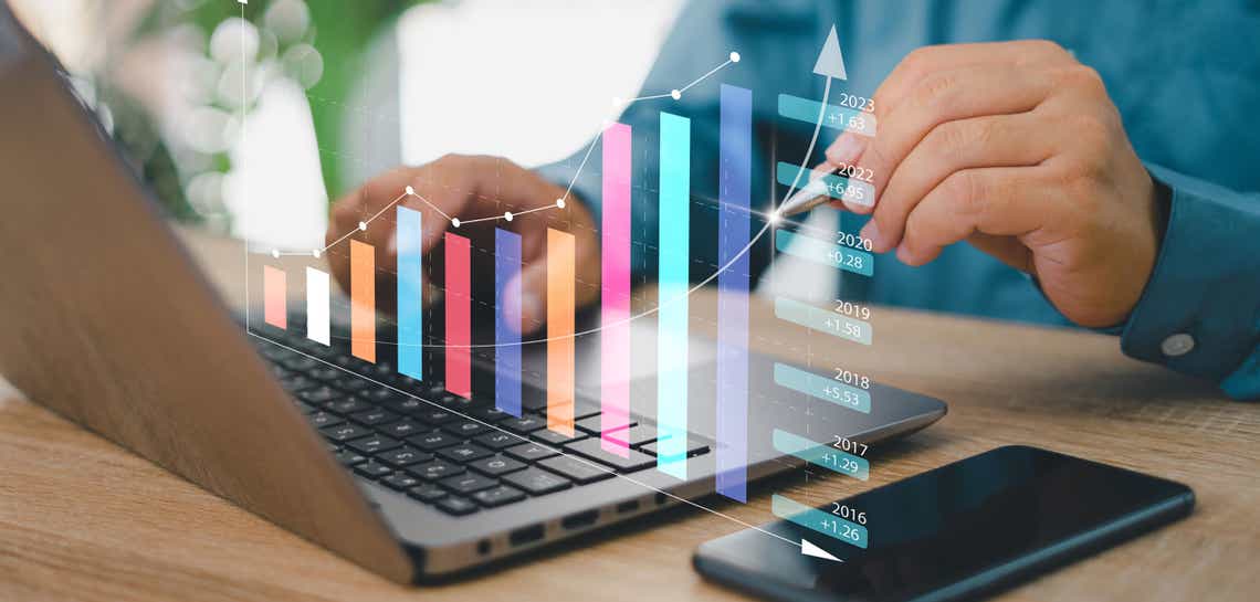 Man on laptop with chart graphic overlay showing positive growth. 