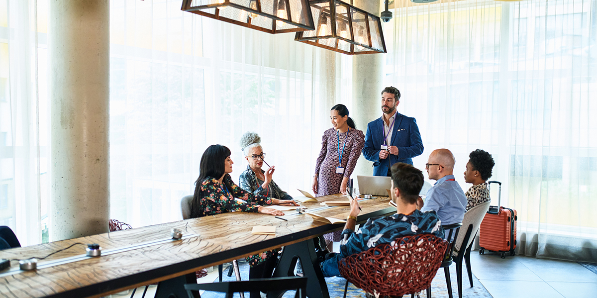 group of sales people gathered around a table reaping the benefits of their company offering continuous sales training