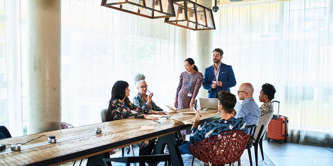 group of sales people gathered around a table reaping the benefits of their company offering continuous sales training