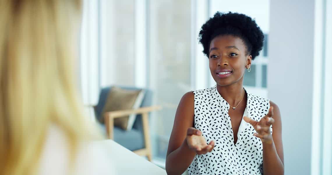 female sales leader engaging a sales rep in a productive performance improvement conversation using the skills she has built by participating in training programs from Richardson's sales management curriculum