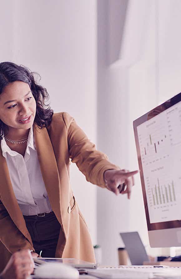 sales manager looking at a desktop reviewing metrics that show the impact of sales training on their team's performance.