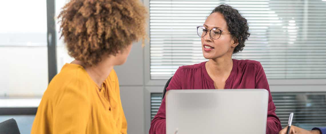 close up of a sales woman and her customer having an engaging conversation at a conference table