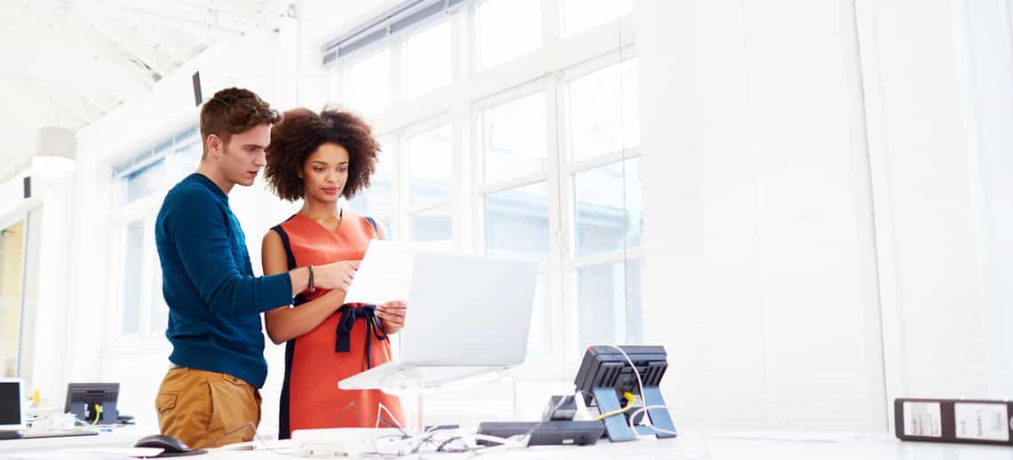 young male and female account rep reviewing their strategic account plans to make sure they're making the most of changes in their customer's business