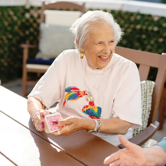 Woman sitting at a table shuffling cards