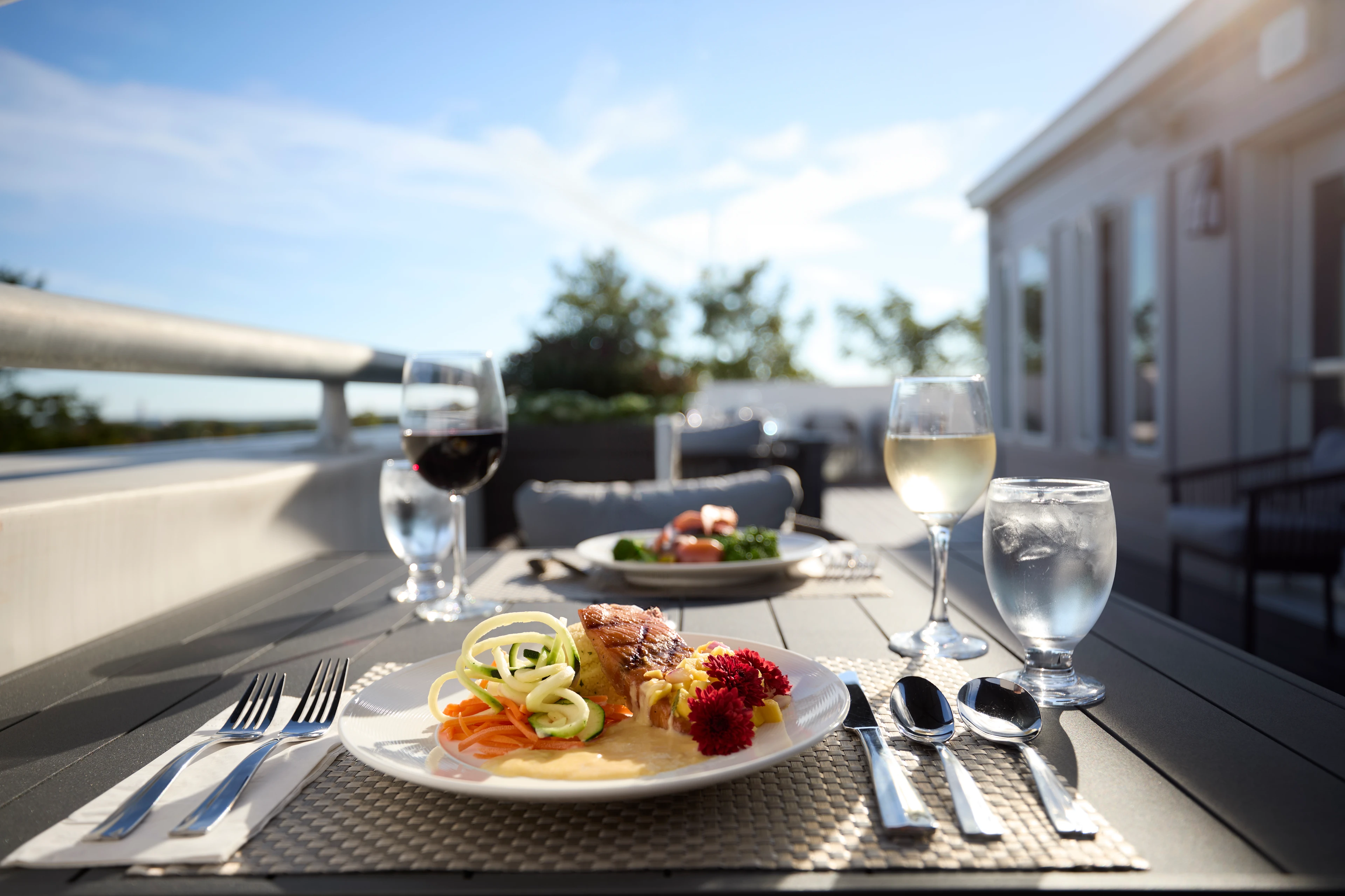 Two elegant meals outdoors with wine