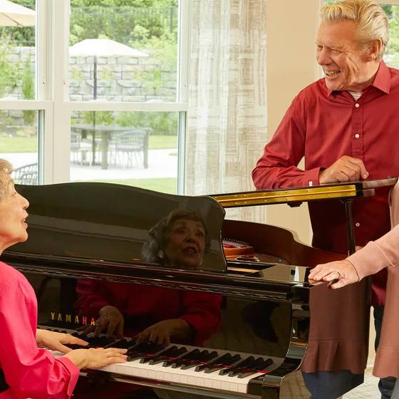 Woman and Couple singing at Piano