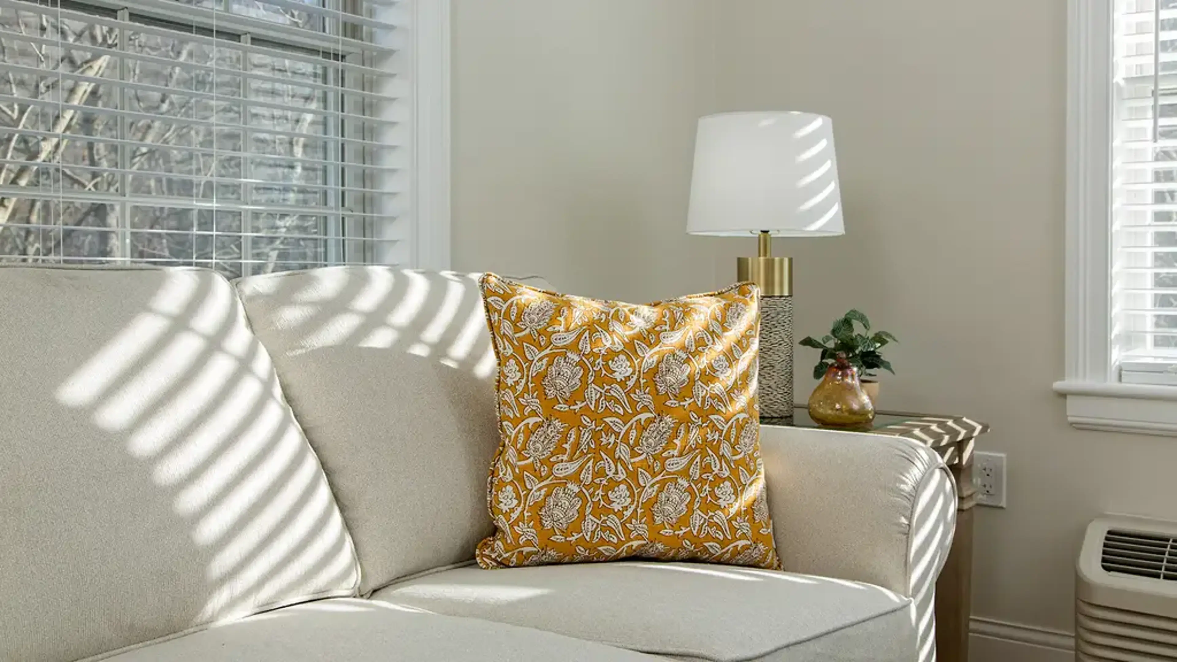 A couch with an orange pillow on it