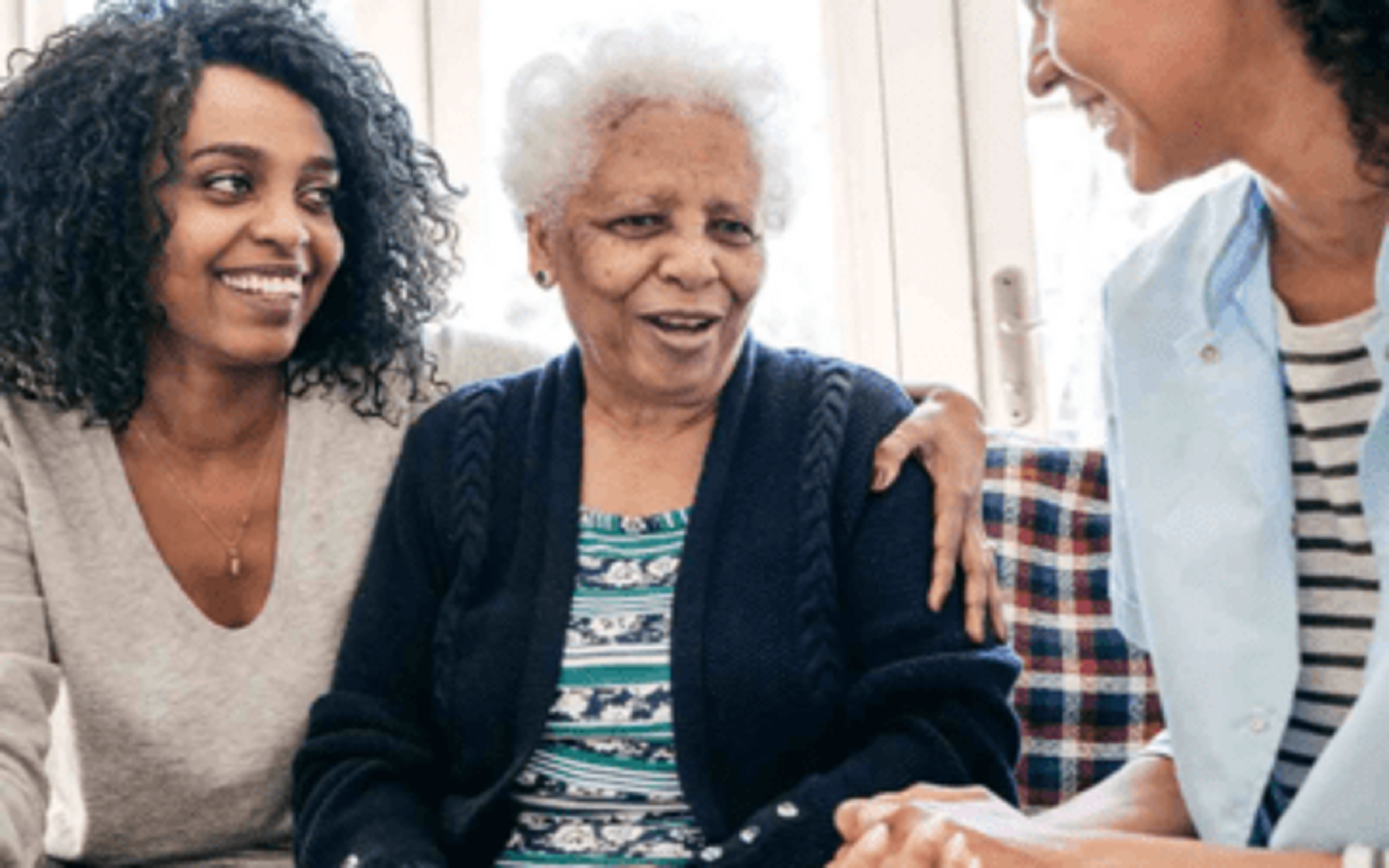 Younger woman with arm around senior woman
