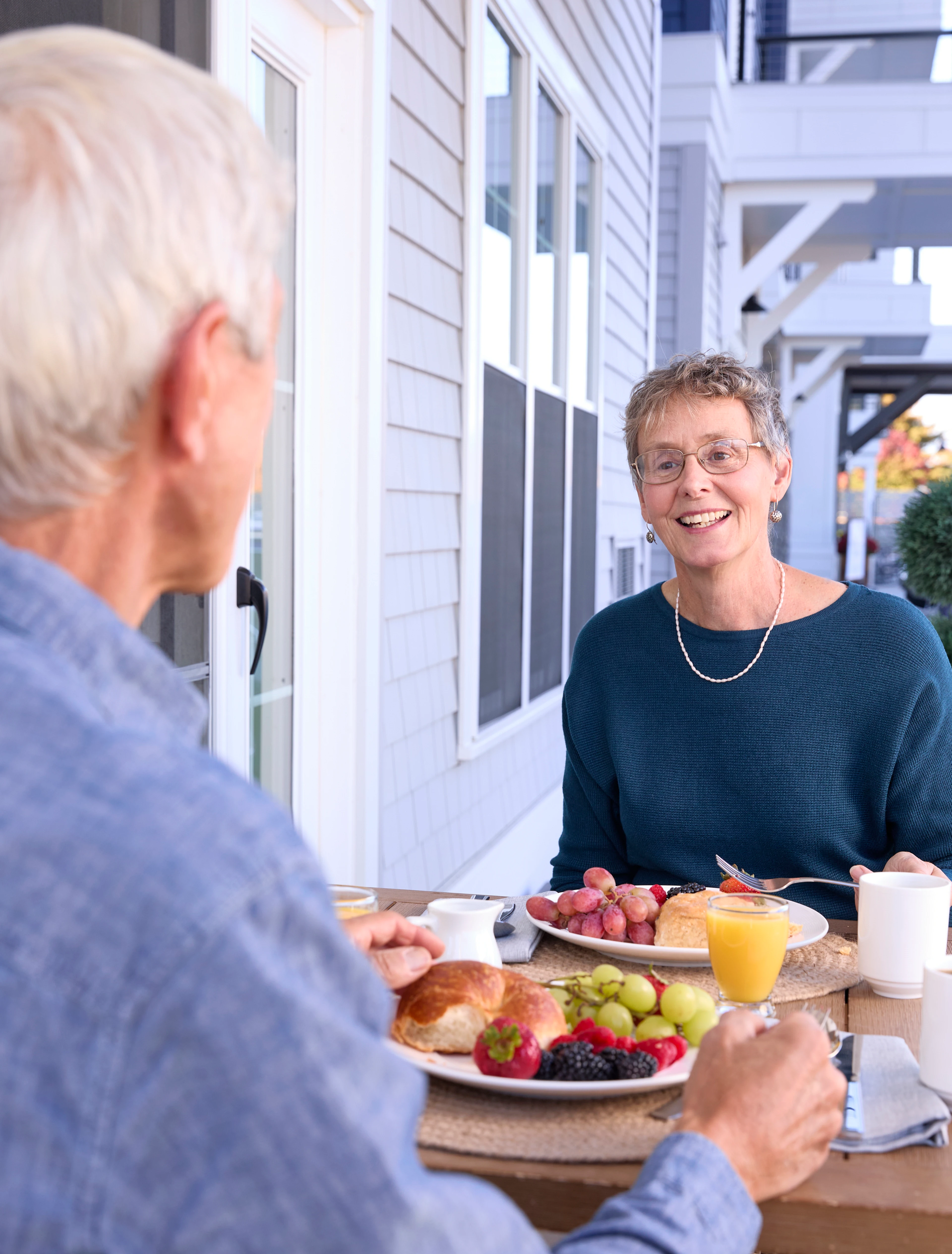 A senior man and woman having a meal together with fresh fruit and orange juice
