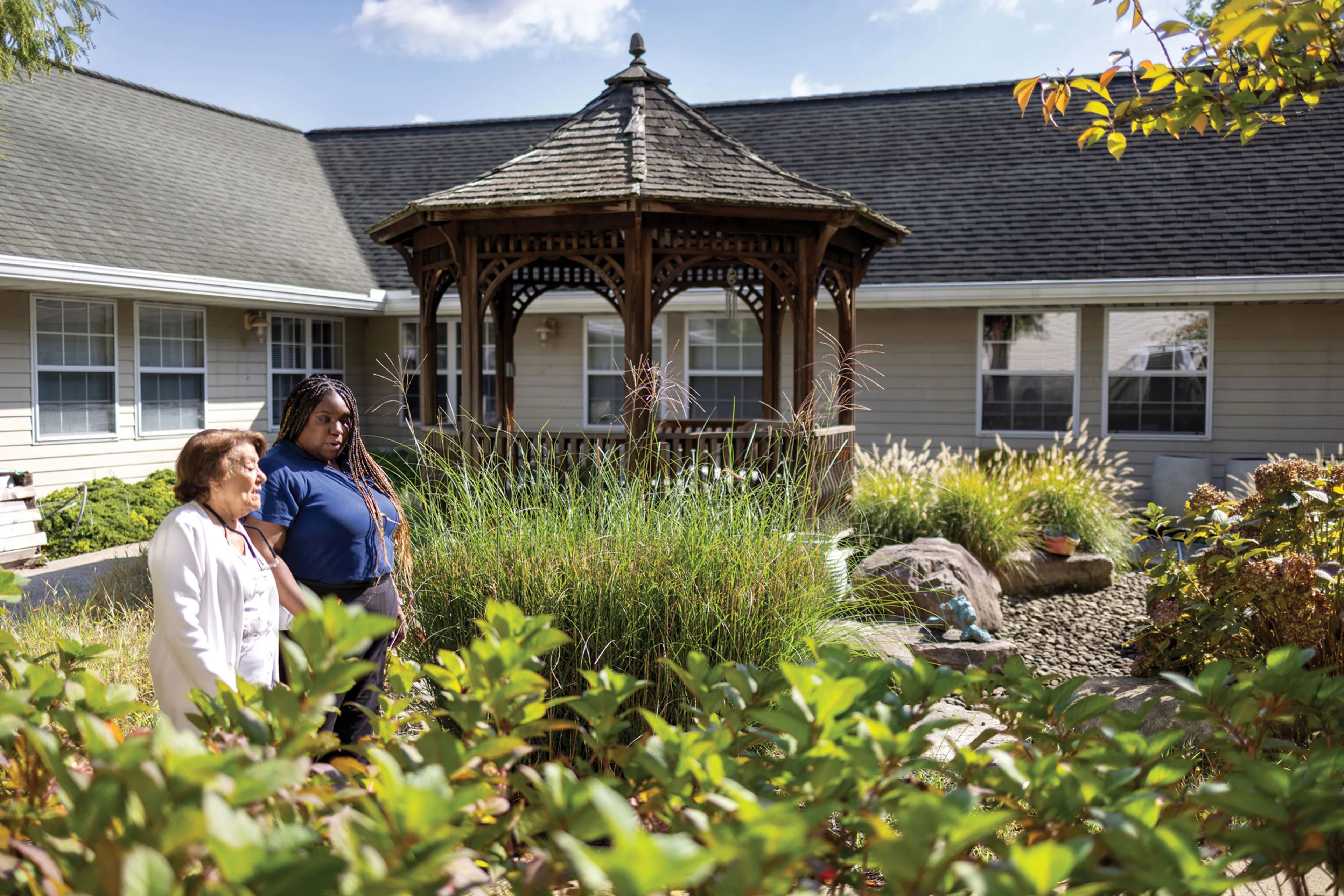 Memory Care Resident Enjoying Beautiful Courtyard with Caregiver