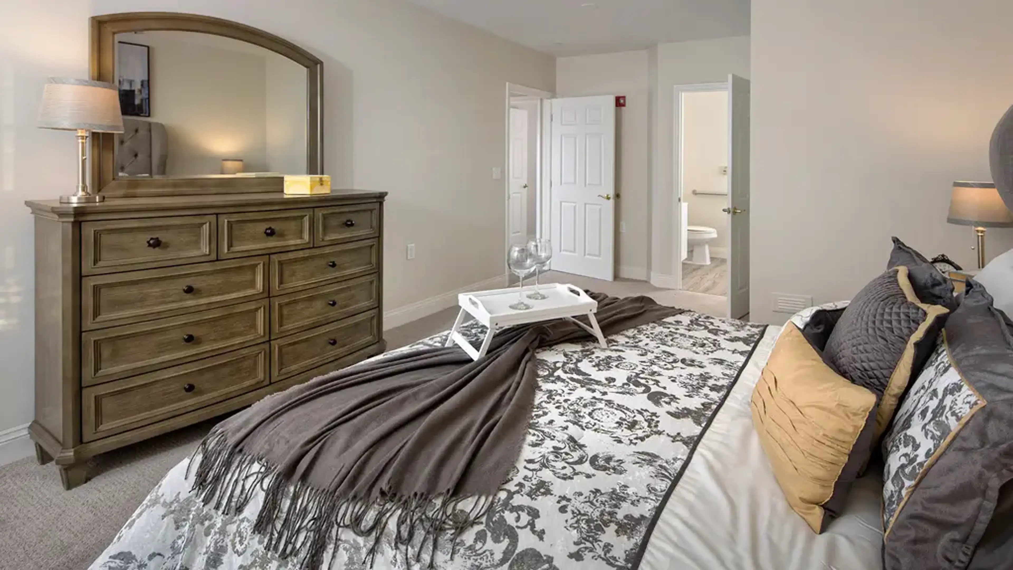 Image of a folding table holding two wine glasses on a bed