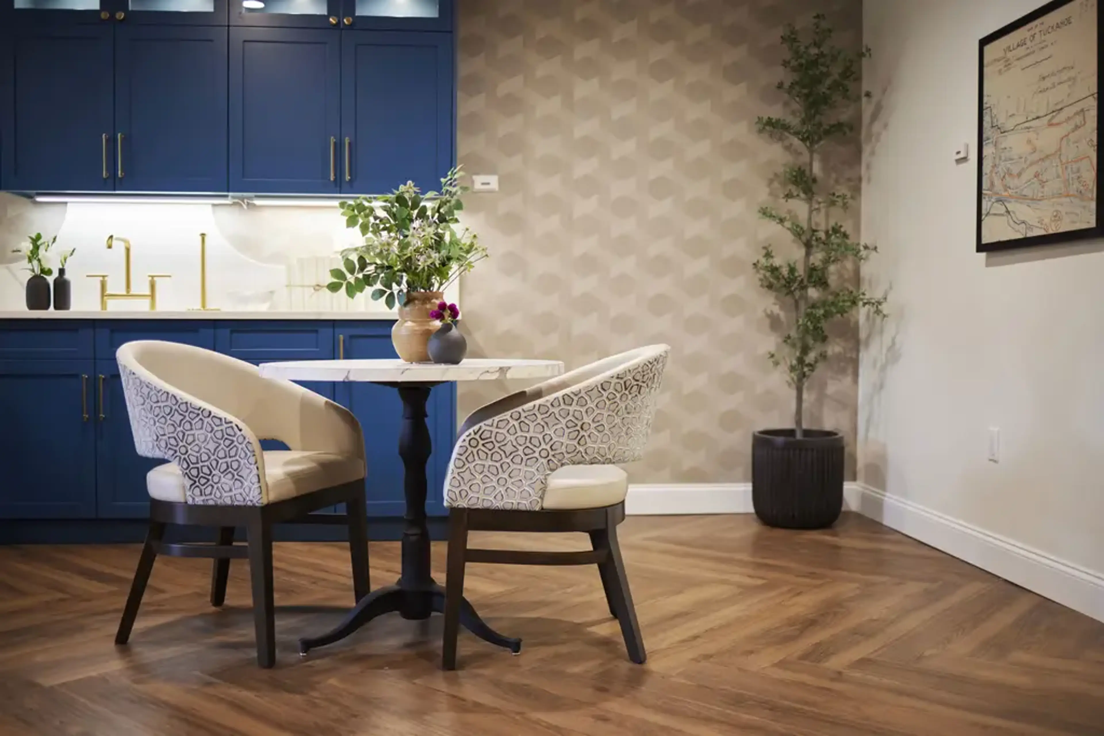 A coffee areas with a table and a vase with greenery.