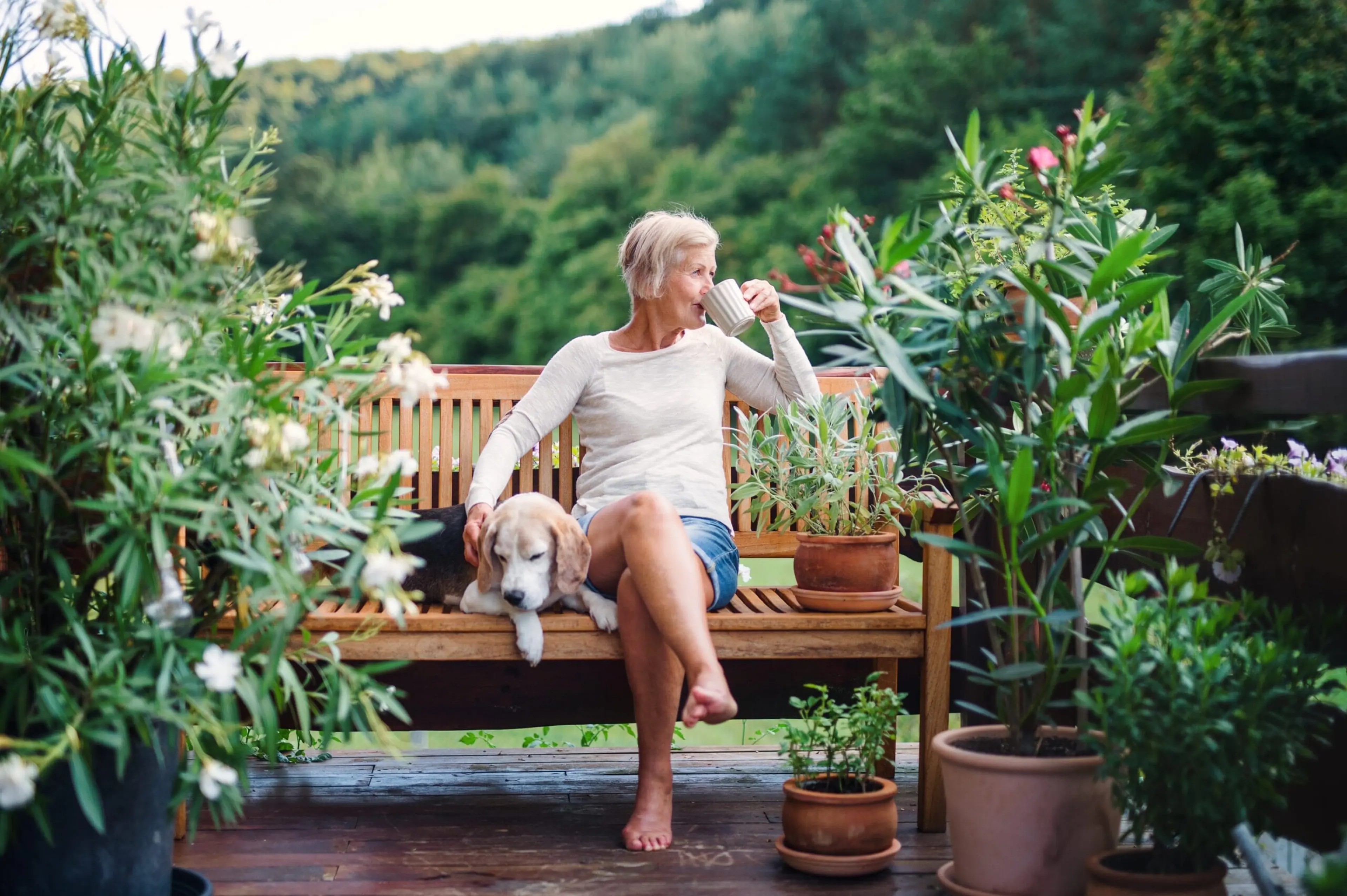 Drinking tea barefoot on a garden bench with a dog