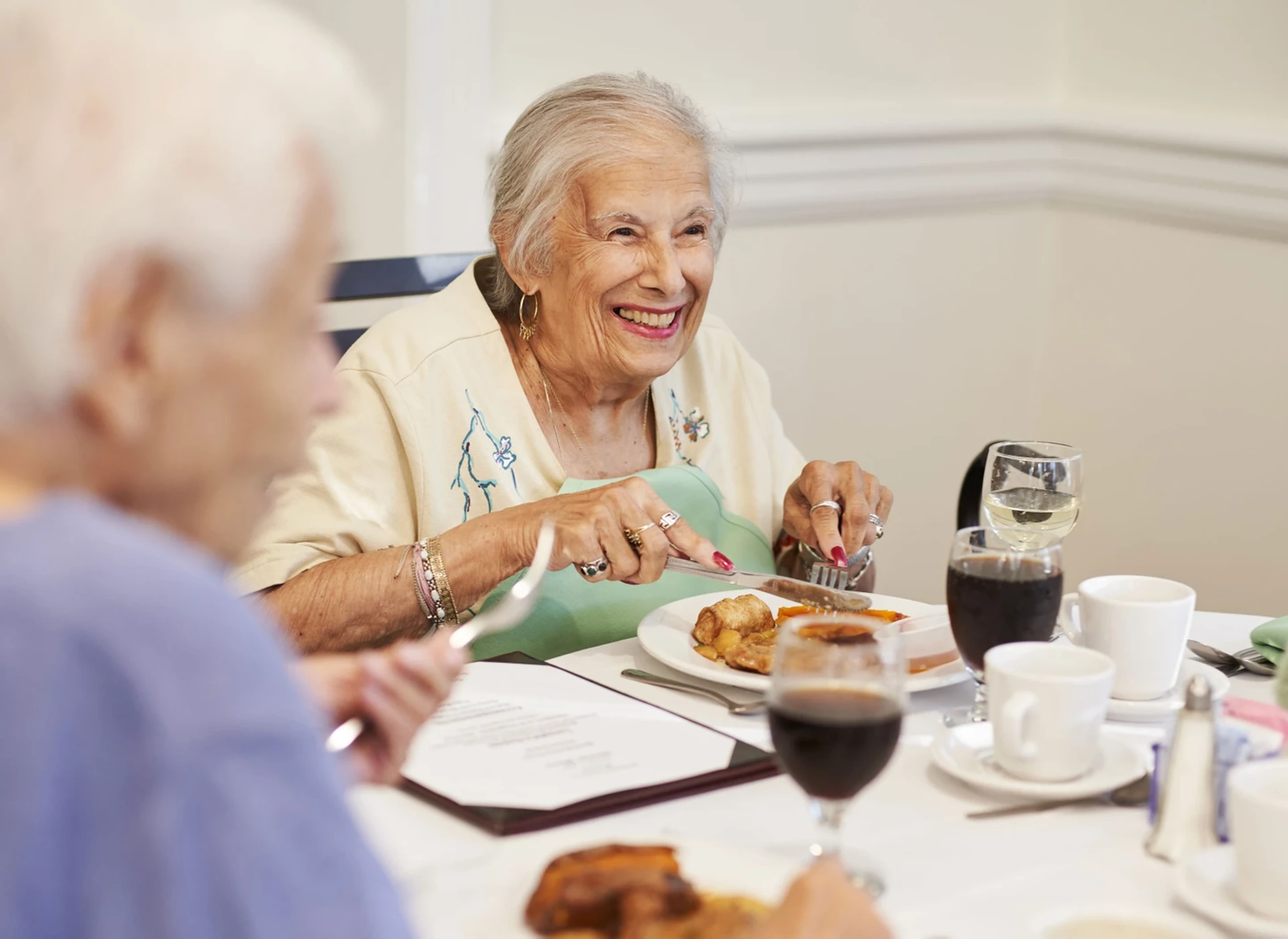 A senior woman smiling and eating
