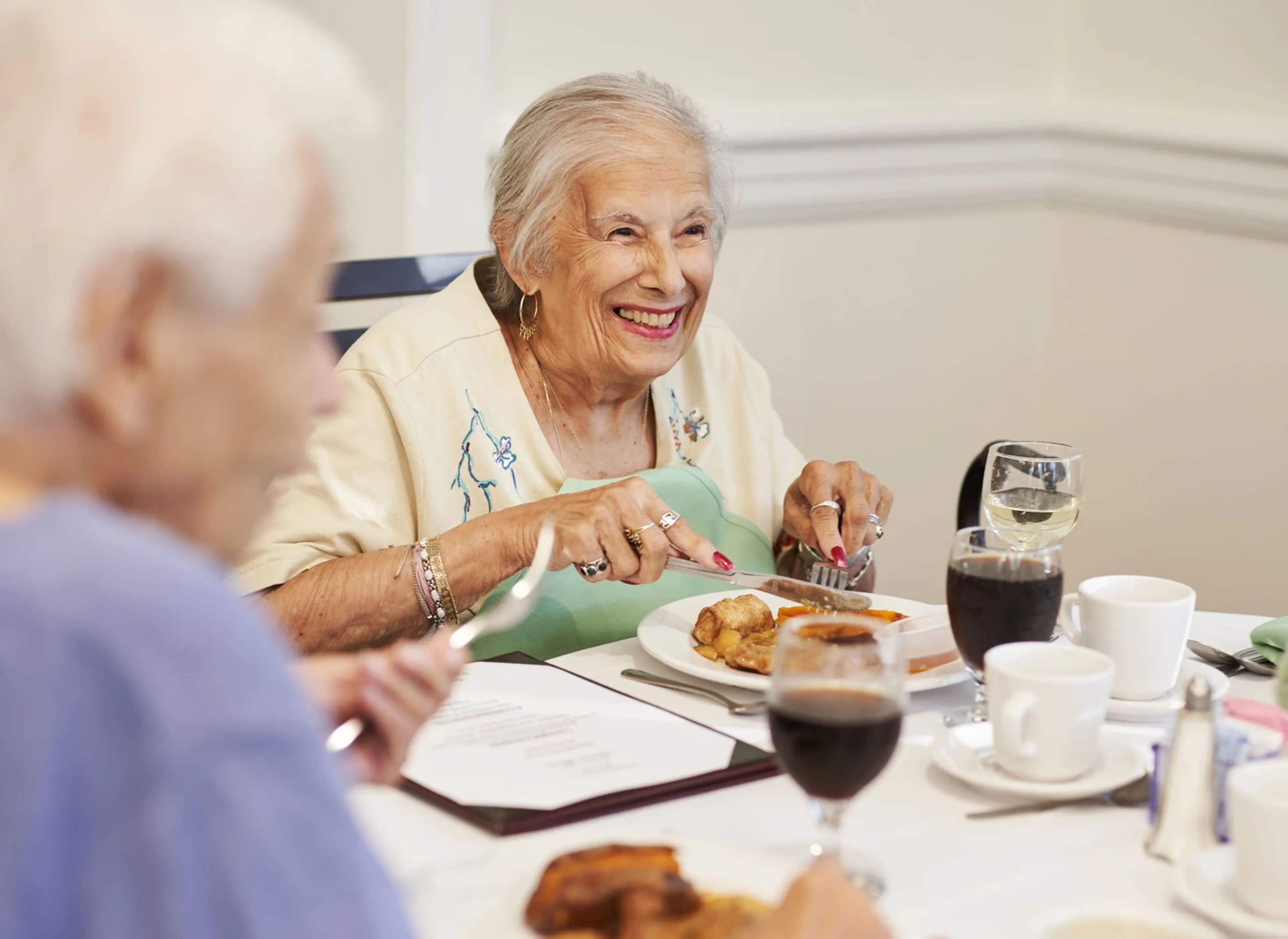A senior woman smiling while eating