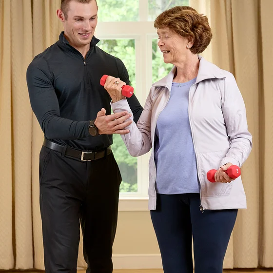 Trainer and woman lifting weight