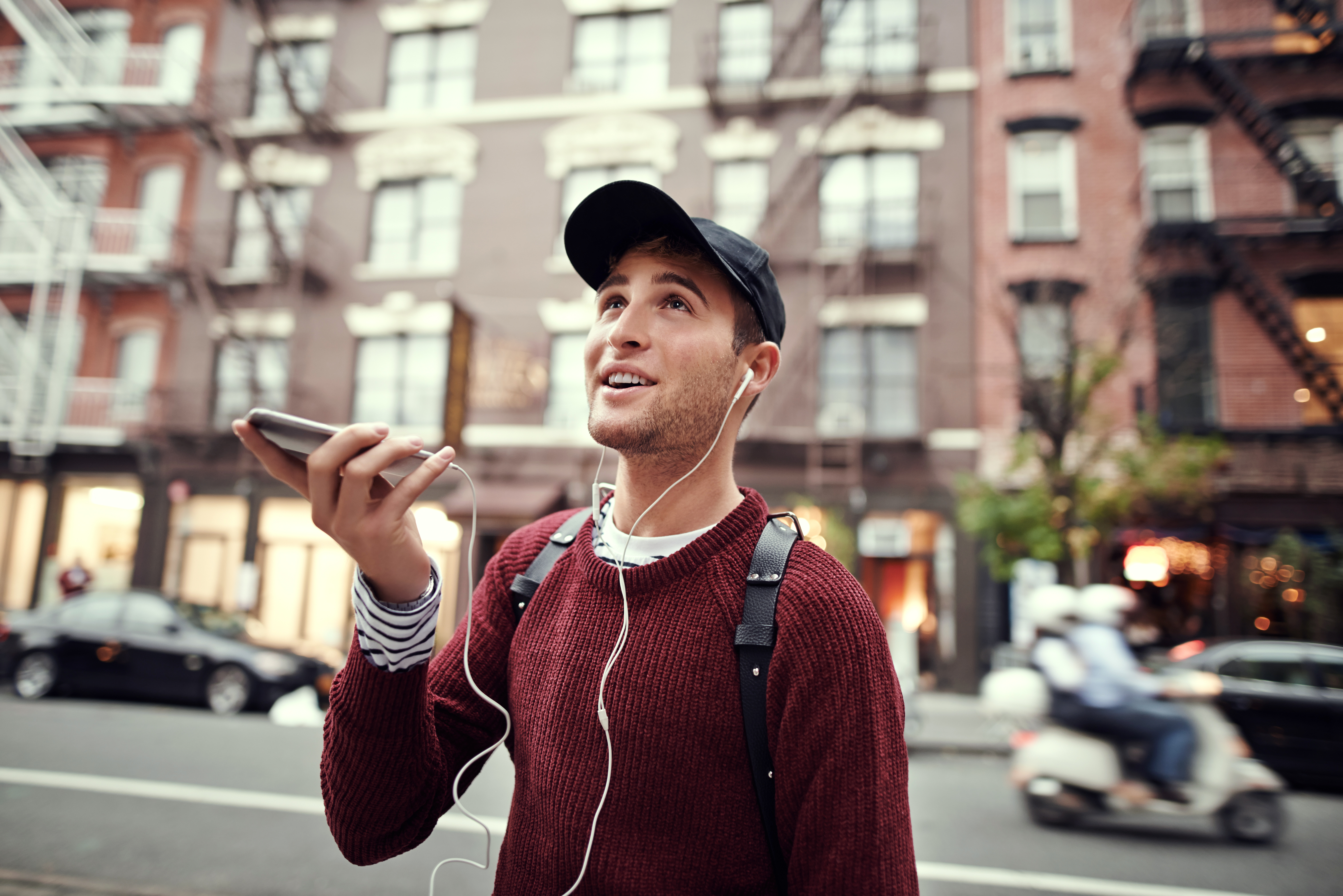 Mann hört mit Smartphone Musik und lernt dabei Sprachen