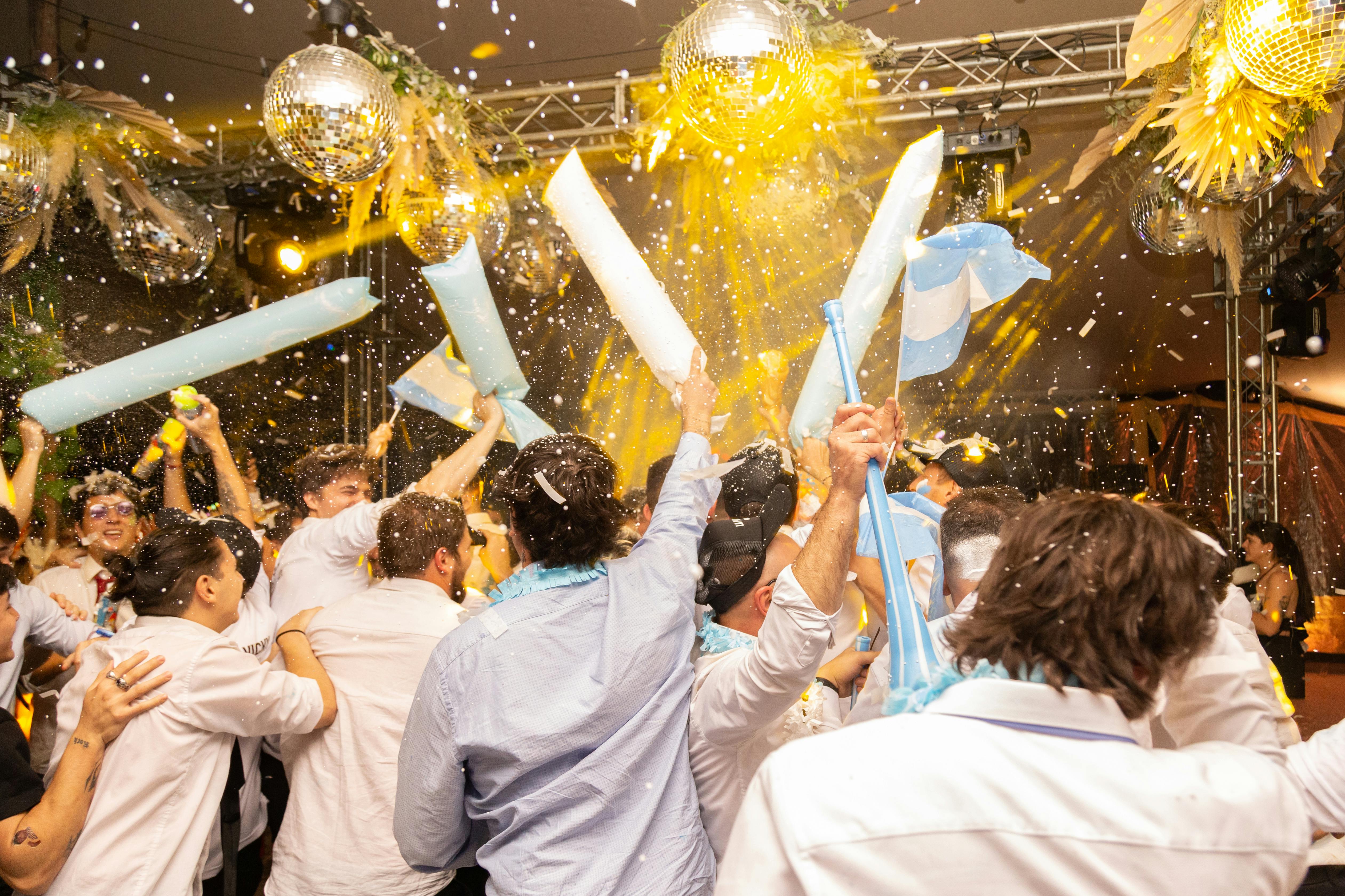 Personen feiern mit Argentinien-Flaggen und Konfetti