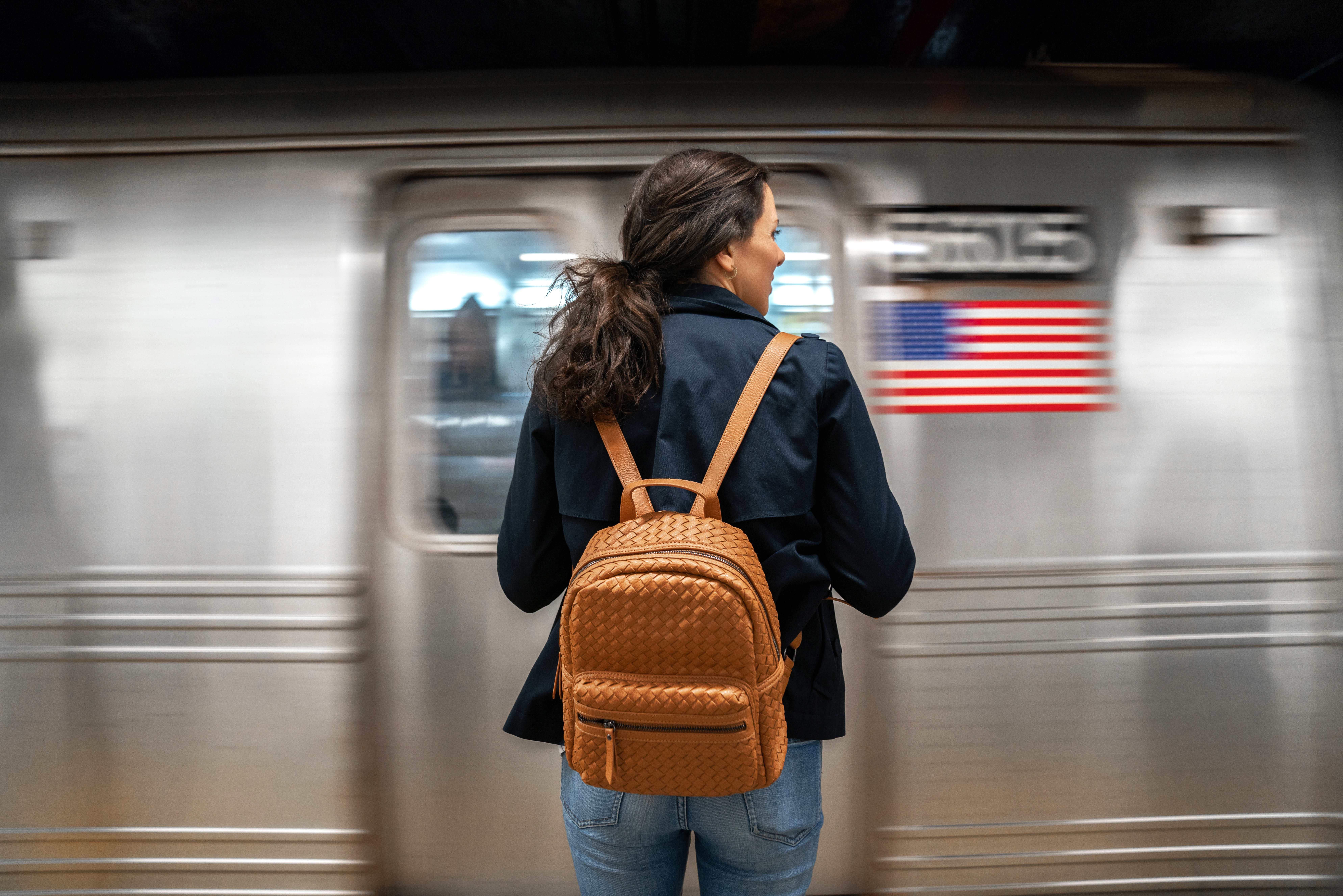 Frau steht vor U-Bahn.