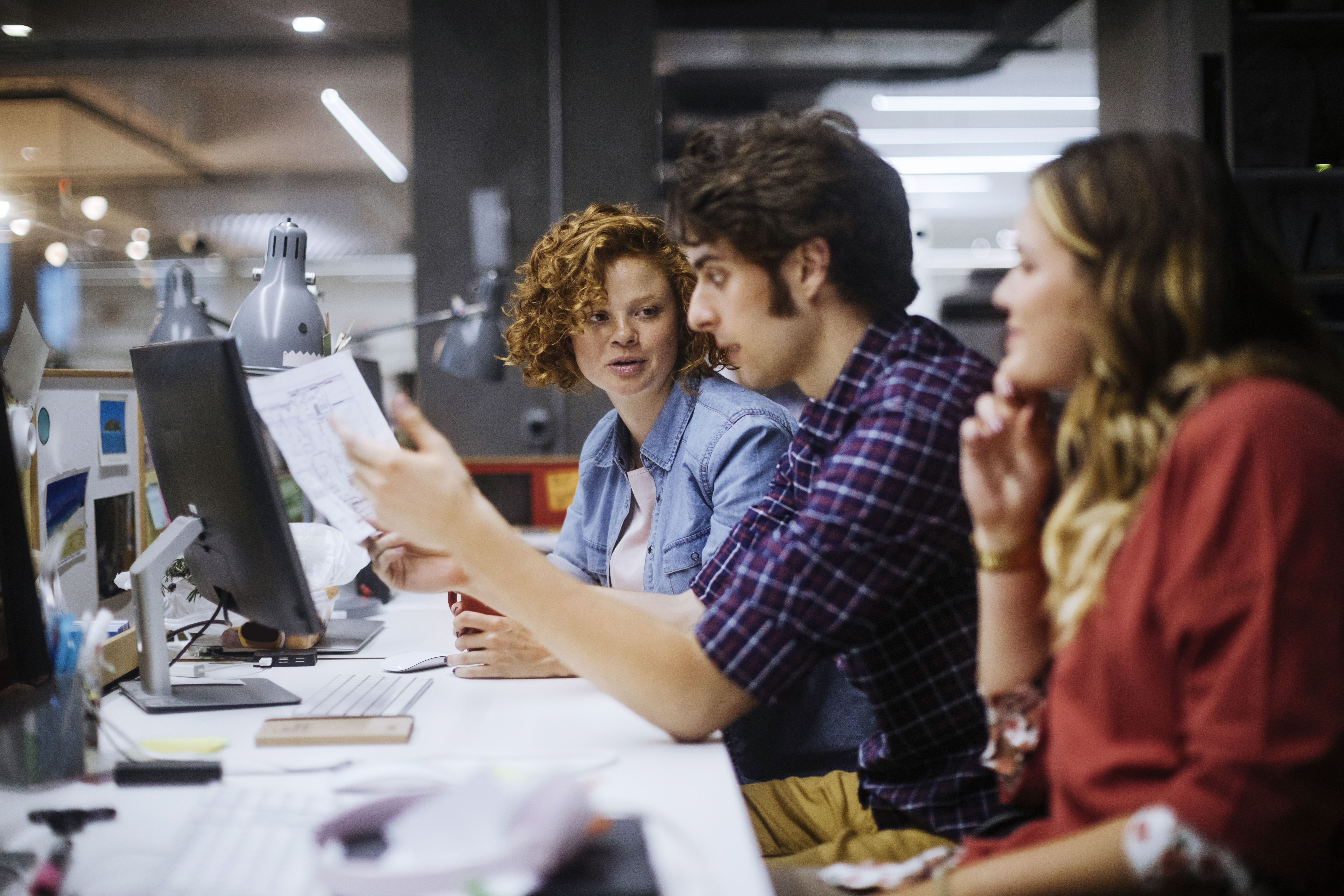 Drei Personen arbeiten gemeinsam am Computer.