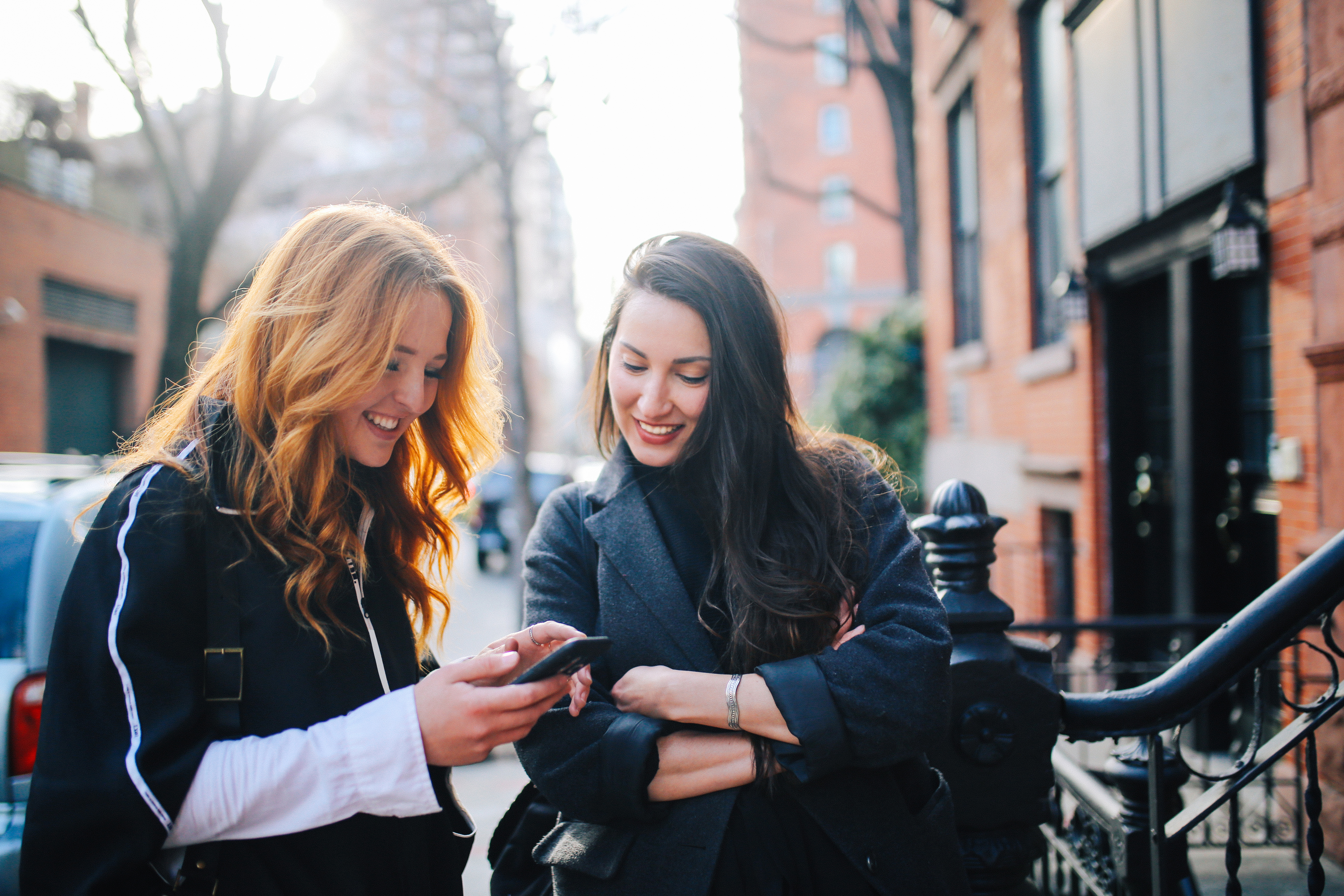 Zwei Frauen schreiben Nachricht am Smartphone