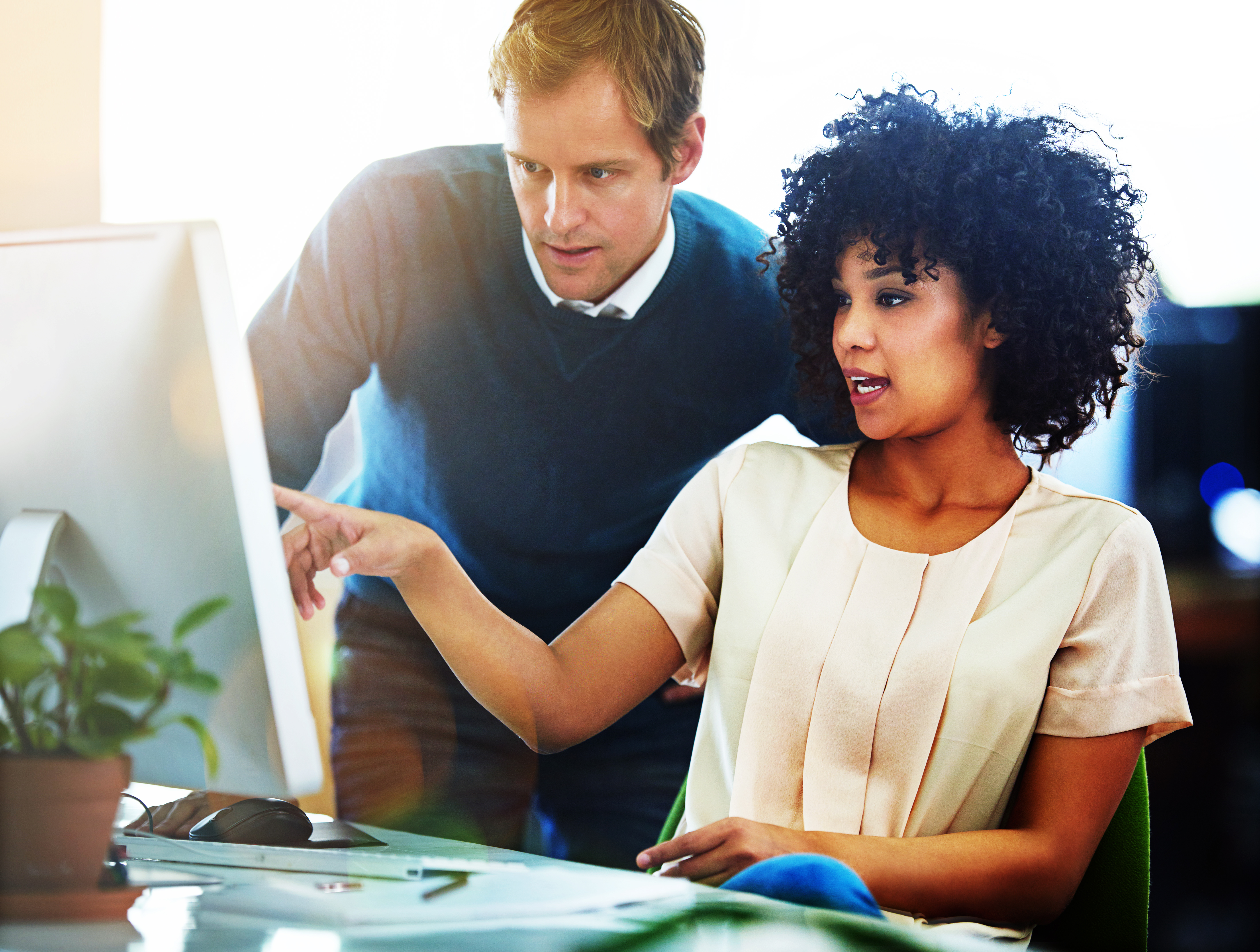 Frau und Mann unterhalten sich am Computer.