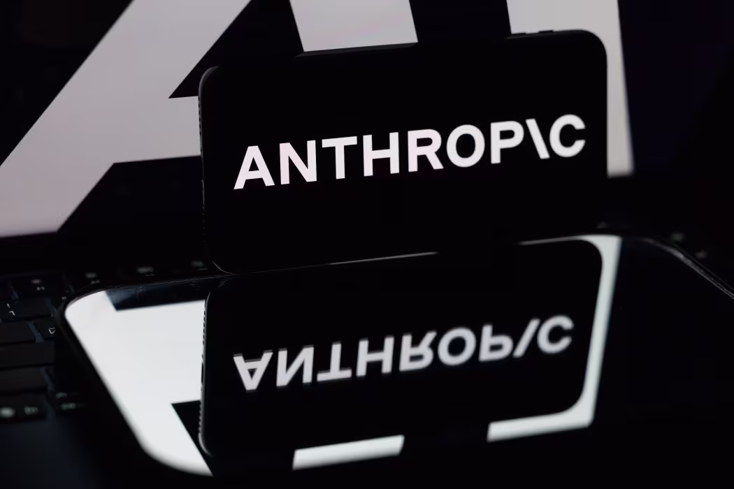 A black Anthropic sign reflected on a glossy surface.