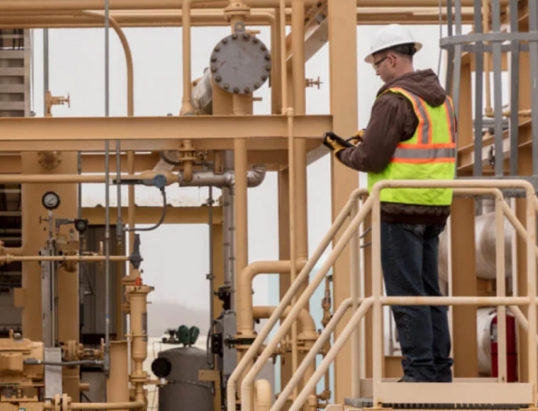 Tile| Utility worker standing on stairs looking at a phone