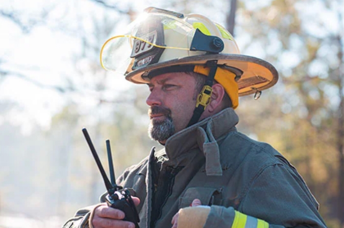 Tile|Firefighter in uniform and helmet while holding walkie-talkie