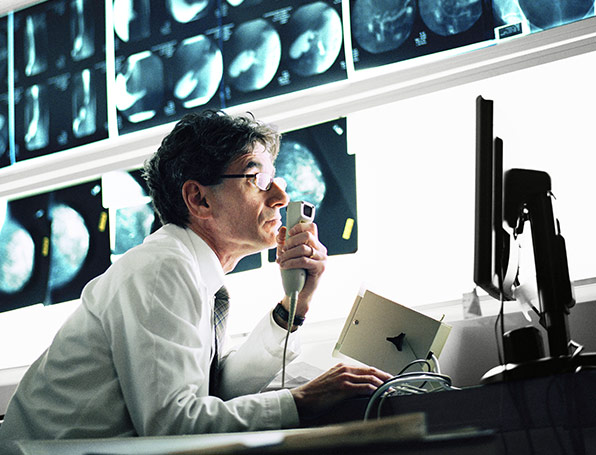 Sqre|Man examining X-rays at computer