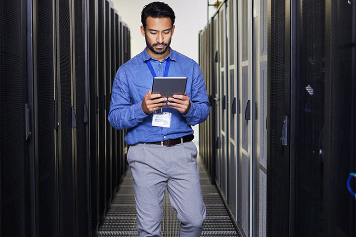 IT_tech_engineer_walking_in_data_center_using_tablet_4448f7e8-b5db-4770-ac8a-e54a40b86a3e.jpg