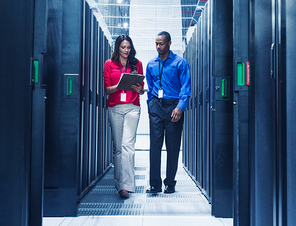 Sqre|Woman and man walking between server racks