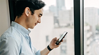 Wide|Businessman viewing his smartphone and smiling