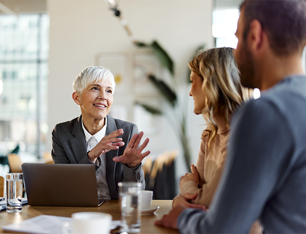 Sqre| Couple talking to a woman seated in front of a laptop