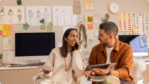 Wide|two people in office discussing with a tablet