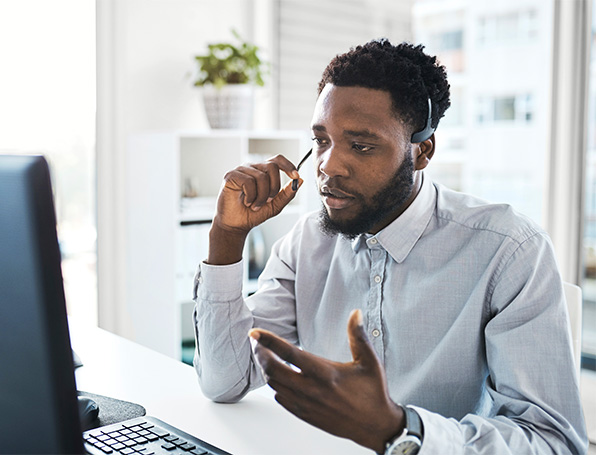 Sqre|Business man talking on headset in front of computer