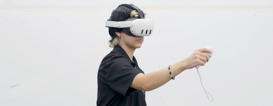 Wide|Person wearing a VR headset using a controller.