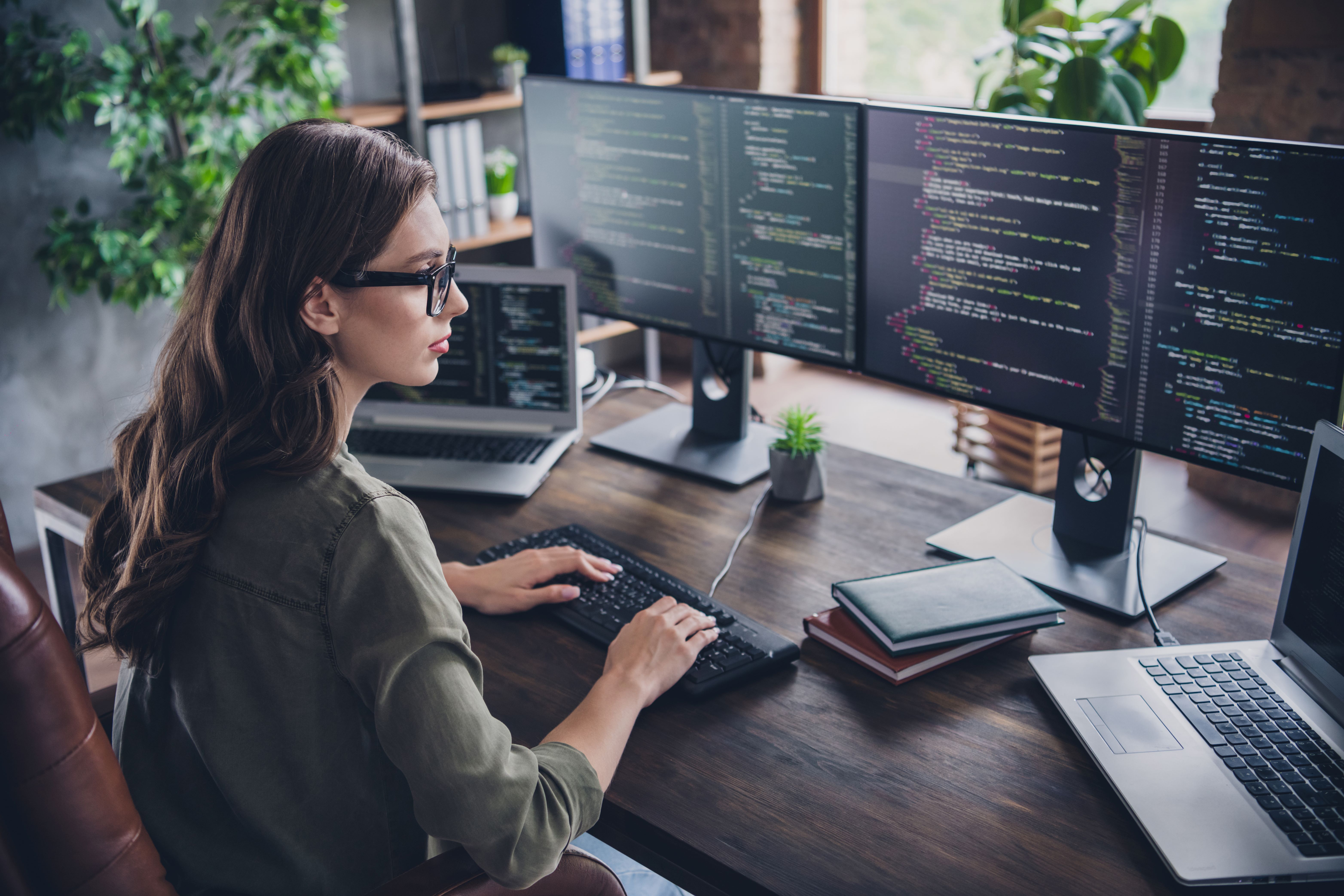 lady with glasses sitting in front of keyboard and monitors1.jpg