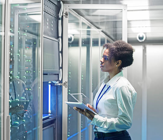 Sqre| Woman standing in a data center with a tablet