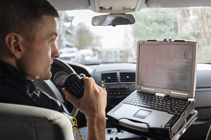 Tile | Policeman in a car with laptop