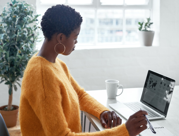 Sqre|Woman sitting at her desk, using a laptop