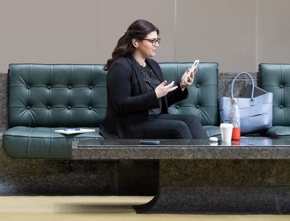 Sqre|Woman in lobby on a conference call.