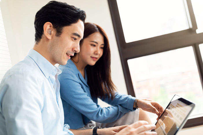 Tile|Two people looking at a laptop