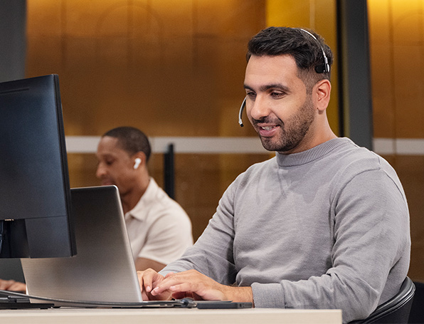 Sqre|Man typing on computer with headset on