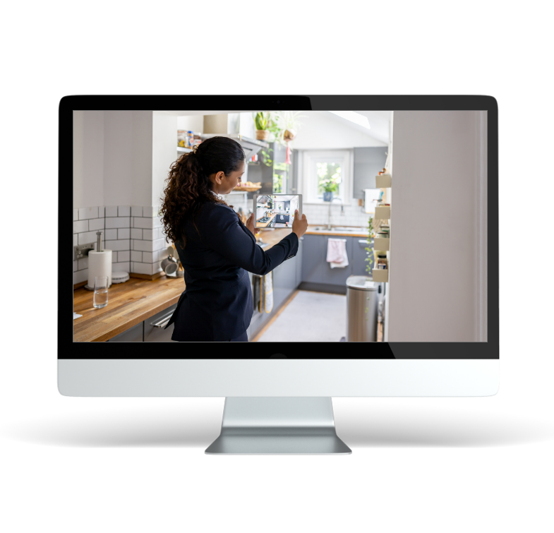 A woman is standing in front of a computer screen.