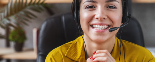 A smiling woman wearing a headset in an office.