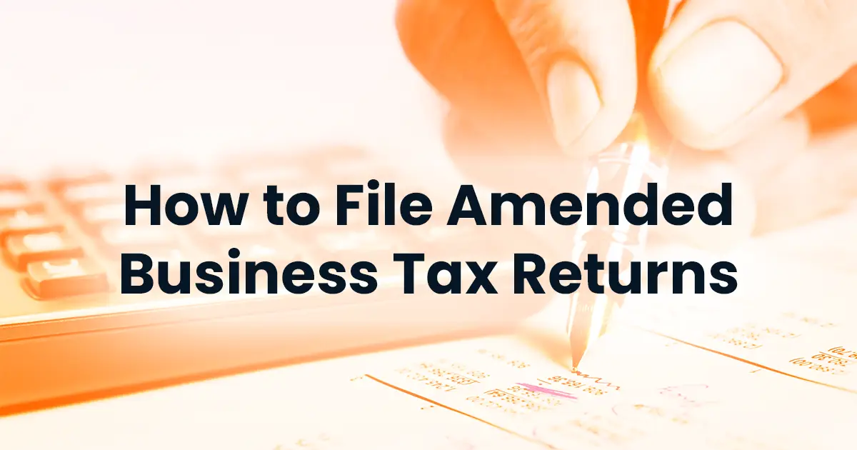 Text overlay "how to file amended business tax returns" on an image of a hand using a calculator over tax documents.